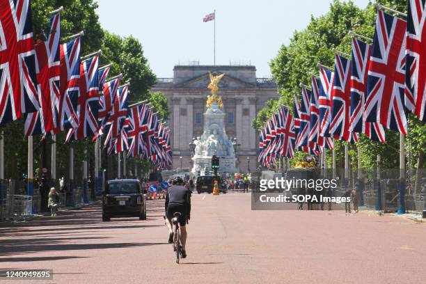 People walk across the Mall, adorned by Union Jack flags, ahead of the Platinum Jubilee celebration. In June, Her Majesty The Queen will be...