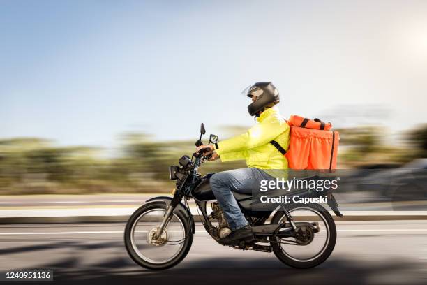 delivery man riding a motorcycle - motoboy - motorbike ride stock pictures, royalty-free photos & images