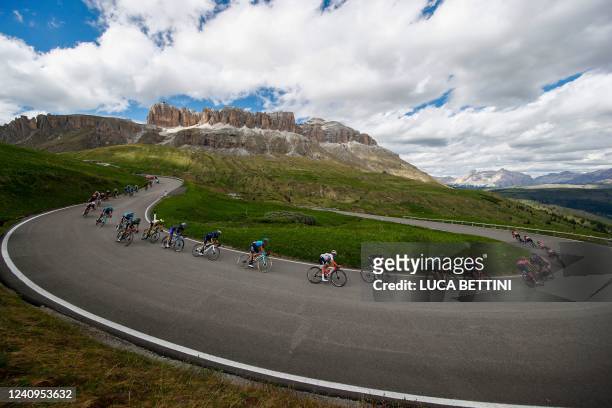 Overall leader Team Ineos' Ecuadorian rider Richard Carapaz and riders of the pack cycle down the Pordoi pass chasing breakaway groups during the...