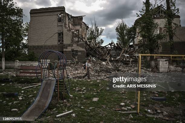 Man walks in front of a destroyed school in the city of Bakhmut, in the eastern Ukranian region of Donbas on May 28 on the 94th day of Russia's...