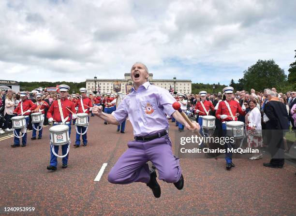 An Orange bandsman jumps as he leads his band at Stormont as the Northern Ireland Centennial parade takes place on May 28, 2022 in Belfast, Northern...