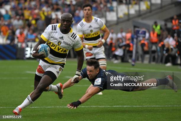 La Rochelle's South African wing Raymond Rhule avoids a tackle and runs to score during the European Rugby Champions Cup, rugby union final between...