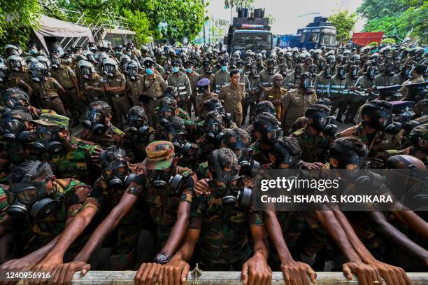 Soldiers stand guard behind barriers as protesters gather during the 50th day of anti-government protests demanding the resignation of Sri Lanka's...