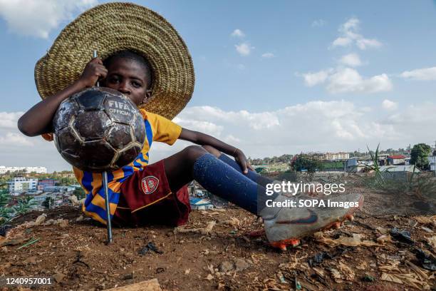 Samuel Oduor takes a posture holding a metallic FIFA soccer before the arrival of the World cup trophy tour in Nairobi. The FIFA World Cup trophy...