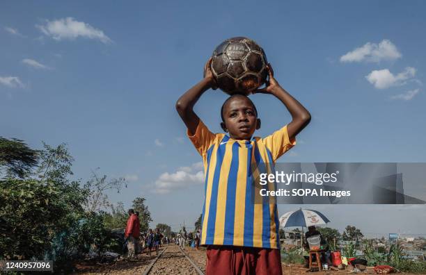 Samuel Oduor takes a posture carrying a metallic FIFA soccer prior to the World cup trophy tour in Nairobi. The FIFA World Cup trophy landed in Kenya...