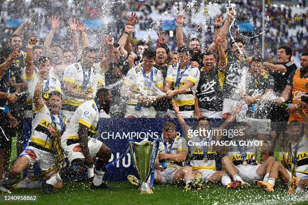 La Rochelle's players celebrate with champagne next to the trophy after winning the European Rugby Champions Cup, rugby union final between Stade...