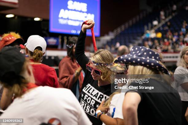 Woman wearing a Hillary for Prison shirt mimics a noose with her tie before former President Donald Trump speaks on May 28, 2022 in Casper, Wyoming....