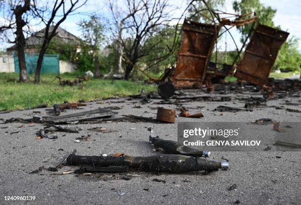 This photograph taken on May 28, 2022 shows abandoned ammunitions next to a destroyed military vehicle near the village of Rus'ka Lozova, north of...