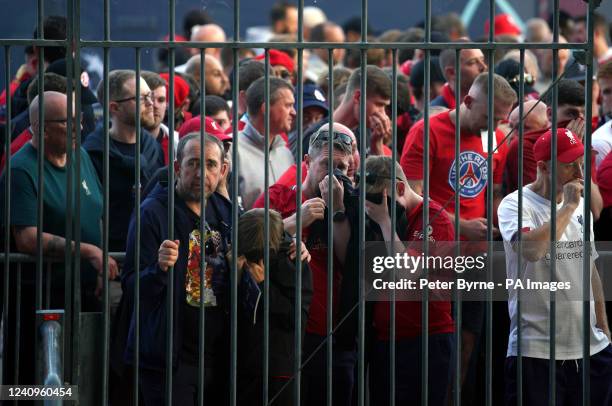 Liverpool fans cover their mouths and noses as they queue to gain entry to the stadium as Kick off is delayed ahead of the UEFA Champions League...