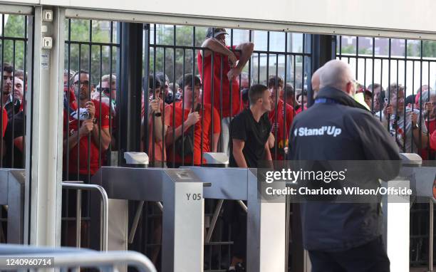 Liverpool supporters look through the closed gates of the Stade de France, some feeling the effects of tear gas before the UEFA Champions League...