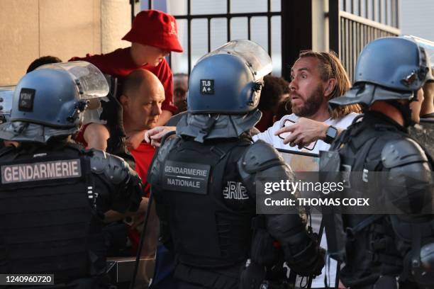 Police stand in front of fans prior to the UEFA Champions League final football match between Liverpool and Real Madrid at the Stade de France in...