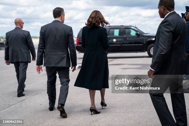 Vice President Kamala Harris turns away to board Air Force 2 with Second Gentleman Doug Emhoff looks on, under the wing of Air Force 2...