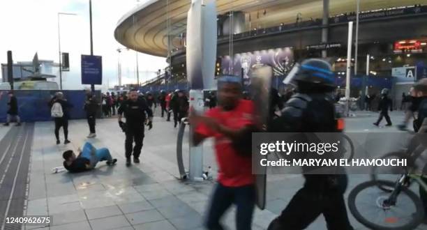 This grab taken from an AFP video shows the police intervening as fans climb the fence of the Stade de France before the UEFA Champions League final...