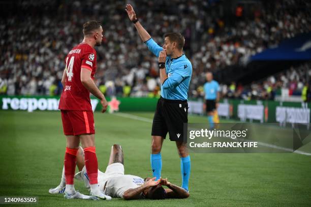 Real Madrid's Brazilian defender Eder Militao reacts as French referee Clement Turpin blows the whistle as Liverpool's English midfielder Jordan...