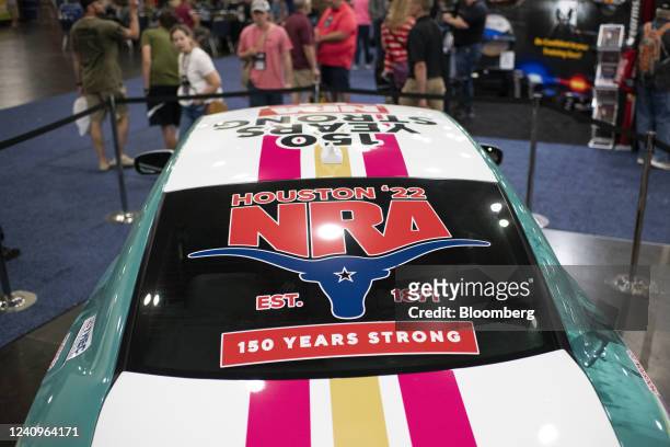 Attendees look at an decorated car during the National Rifle Association annual convention in Houston, Texas, US, on Saturday, May 28, 2022. The...