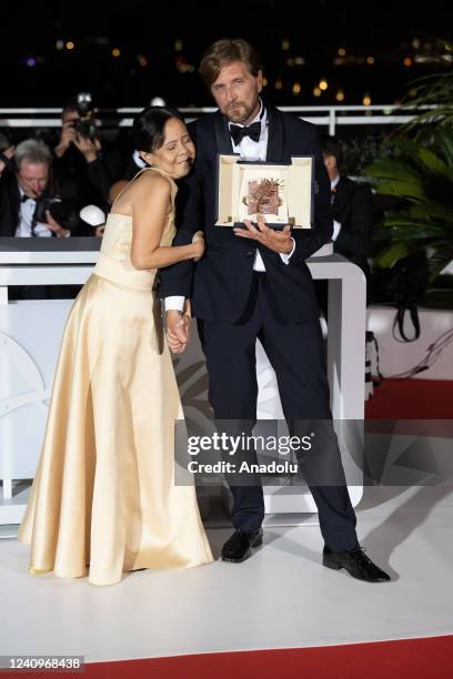 Dolly De Leon and Director Ruben Ostlund pose with the Palme d'Or Award for the movie 'Triangle of Sadness' during the winner photocall during the...