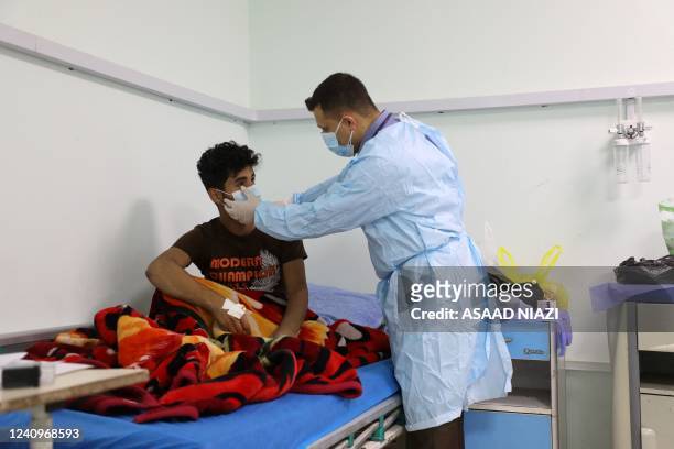 Doctors at a hospital in Iraq's southern Dhi Qar province, examines a patient infected with the tick-borne virus Crimean-Congo haemorrhagic illness ,...