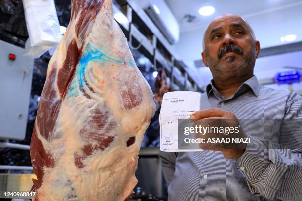 Iraqi butcher Bashar Nahi holds a document that certifies a slaughtered animal as being clear of the tick-borne virus Crimean-Congo haemorrhagic...