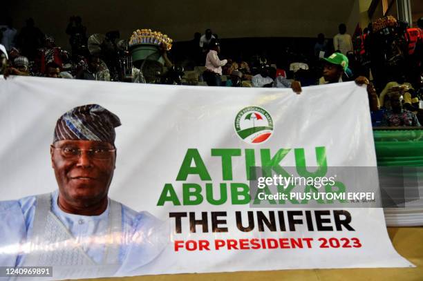 Supporters hold a banner of Nigerian former Vice President Atiku Abubakar during the opposition Peoples Democratic Party's primaries in Abuja, on May...