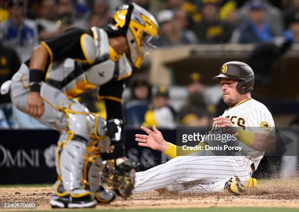Luke Voit of the San Diego Padres scores ahead of the tag by Michael Perez of the Pittsburgh Pirates during the seventh inning of a baseball game at...