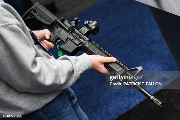 An attendee holds a Springfield Armory SAINT AR-15 style rifle displayed during the National Rifle Association Annual Meeting at the George R. Brown...