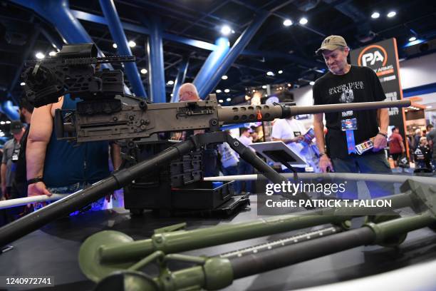 Attendees view a CANiK M2 QCB .50 cal machine gun displayed during the National Rifle Association Annual Meeting at the George R. Brown Convention...