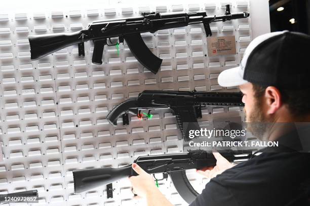 Attendees hold American made AK-47 style 7.62mm semi-automatic rifles from Kalashnikov USA during the National Rifle Association Annual Meeting at...