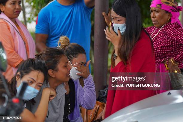 Family members and relatives of passengers on board the Twin Otter aircraft operated by Tara Air, weep outside the airport in Pokhara on May 29,...