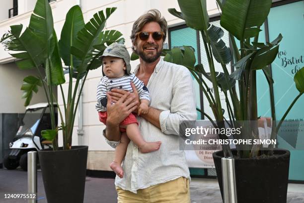 Swedish film director Ruben Ostlund poses with his son the day after winning the Palme d'Or for the film "Triangle of Sadness" at the 75th edition of...