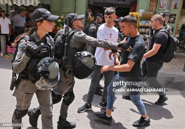 Members of Israeli security scuffle with a Palestinian protester in Jerusalem's Old City, as Israelis mark Jerusalem Day, on May 29, 2022. -...