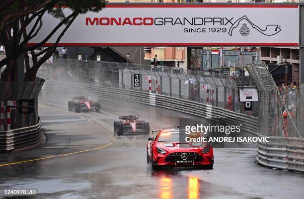 Ferrari's Monegasque driver Charles Leclerc and Ferrari's Spanish driver Carlos Sainz Jr ride under the rain behind the safety car during a formation...
