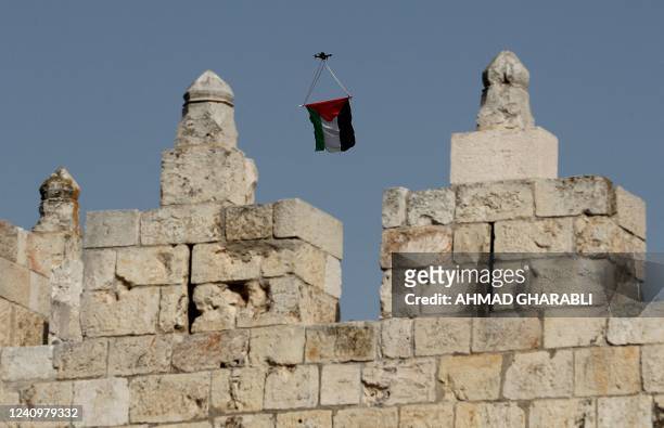 Palestinian flag hanging from a civilian drone flies over the ramparts of the Damascus Gate of the old city of Jerusalem on May 29 during the Israeli...