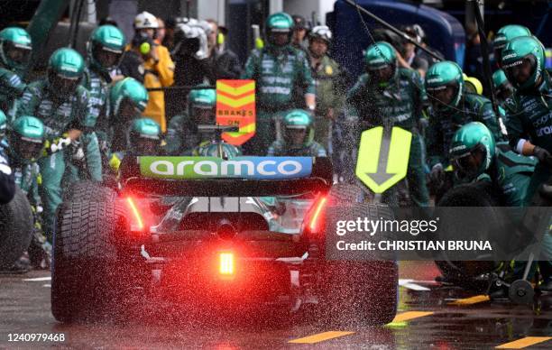 Technicians work on the car of Aston Martin's Canadian driver Lance Stroll in the pit lane during the Monaco Formula 1 Grand Prix at the Monaco...