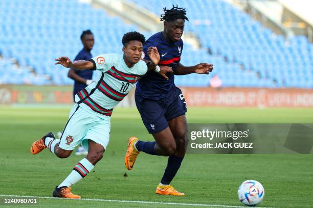 Portugal's forward Ussumane Djalo vies for the ball with France's defender El-Chadaille Bitshiabu during the 2022 UEFA European Under-17 Championship...