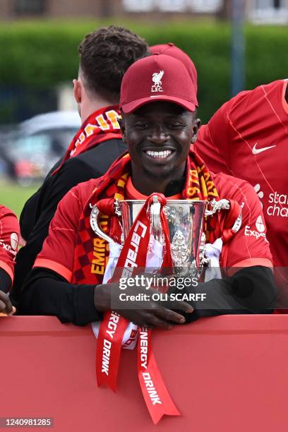 Liverpool's Senegalese striker Sadio Mane holds the League Cup Trophy as he celebrates with temmates on an open-top bus during a parade through the...