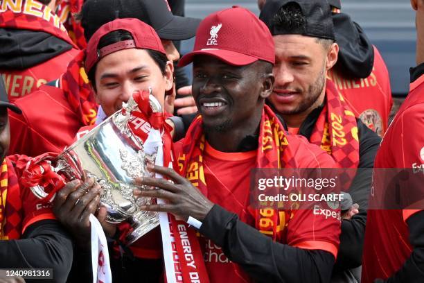 Liverpool's Senegalese striker Sadio Mane holds the League Cup Trophy as he celebrates with temmates on an open-top bus during a parade through the...