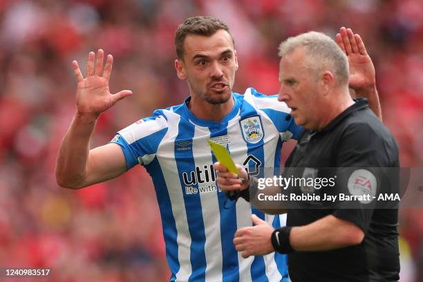 Harry Toffolo of Huddersfield Town pleads to Match referee Jonathan Moss after being shown a Yellow Card for an alleged dive during the Sky Bet...