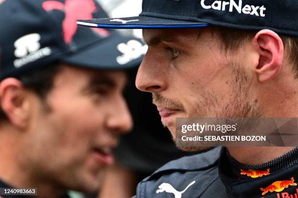 Third-placed Red Bull Racing's Dutch driver Max Verstappen looks on flanekd by winner Red Bull Racing's Mexican driver Sergio Perez after the Monaco...