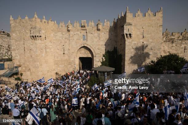 Israeli Jewish citizens dance and hold Israeli flags as they take part at the annual Flag March by Damascus Gate on May 29, 2022 in Jerusalem,...