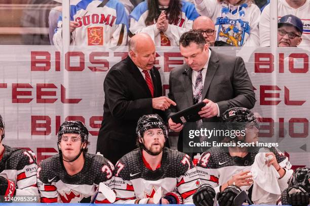 Head coach Claude Julien of Canada talks to assistant coach D J Smith of Canada during the 2022 IIHF Ice Hockey World Championship match between...