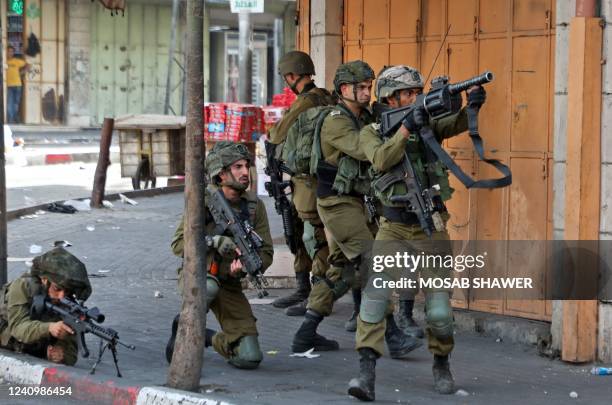 Israeli army soldiers take aim during clashes with Palestinian protesters following a demonstration to denounce the annual nationalist "flag march"...