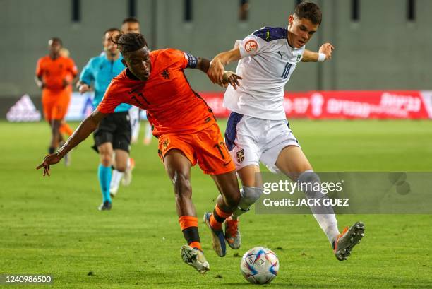 Netherland's midfielder Isaac Babadi vies for the ball with Serbia's defender Kosta Nedeljkovic during the 2022 UEFA European Under-17 Championship...