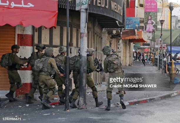 Israeli army soldiers approach Palestinian protesters during clashes following a demonstration to denounce the annual nationalist "flag march"...