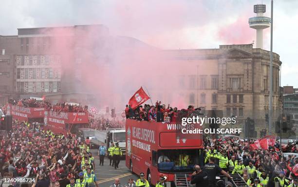 Liverpool's players wave to supporters from an open-top bus during a parade through the streets of Liverpool in north-west England on May 29 to...