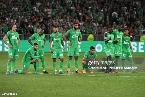 Saint-Etienne's players stand on the pitch during the penalty shoot-out at the end of the French L1-L2 play-off second leg football match between AS...