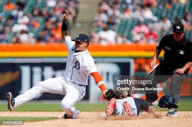 Shortstop Javier Baez of the Detroit Tigers can't field the pickoff throw on a steal of second base by Jose Ramirez of the Cleveland Guardians during...