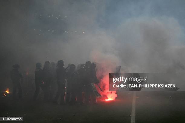 Riot police officers clash with Saint-Etienne's fans who invaded the pitch after being defeated by Auxerre at the end of the French L1-L2 play-off...