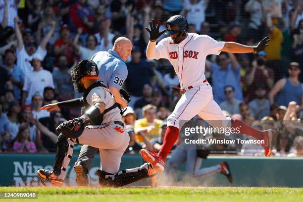 Xander Bogaerts of the Boston Red Sox scores past catcher Robinson Chirinos of the Baltimore Orioles on an error during the fifth inning at Fenway...