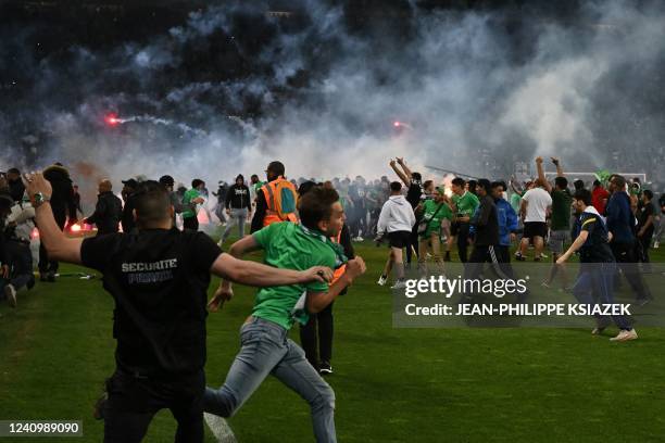 Saint-Etienne's fans invade the pitch after being defeated at the end of the French L1-L2 play-off second leg football match between AS Saint-Etienne...