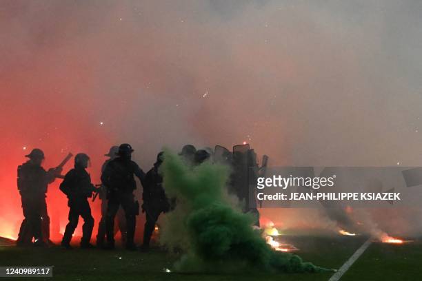 Riot police officers clash with Saint-Etienne's fans who invaded the pitch after being defeated by Auxerre at the end of the French L1-L2 play-off...